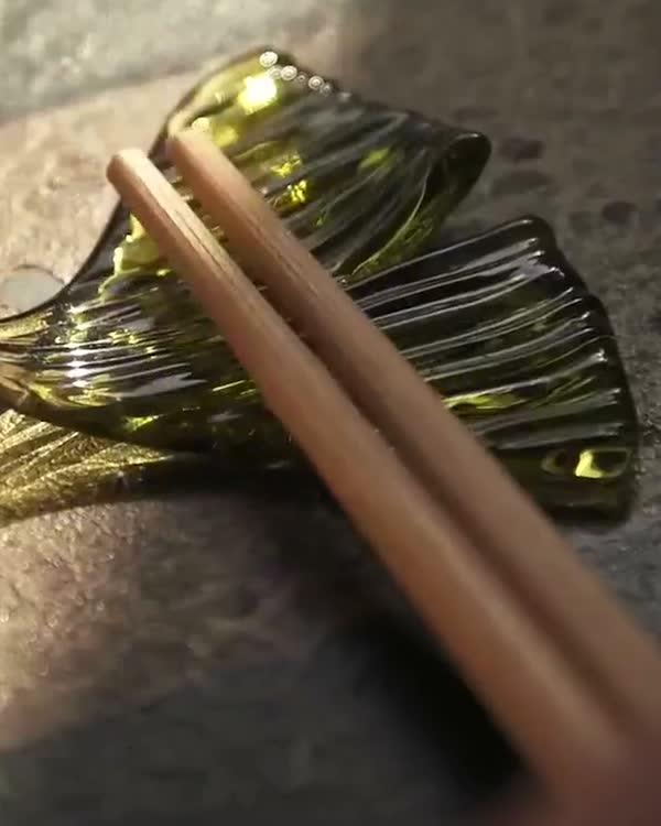 Chopsticks resting on a glass leaf